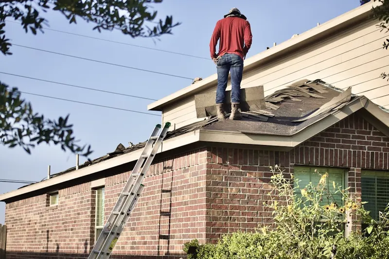 Professional roofer working on a residential roof in West Lynn
